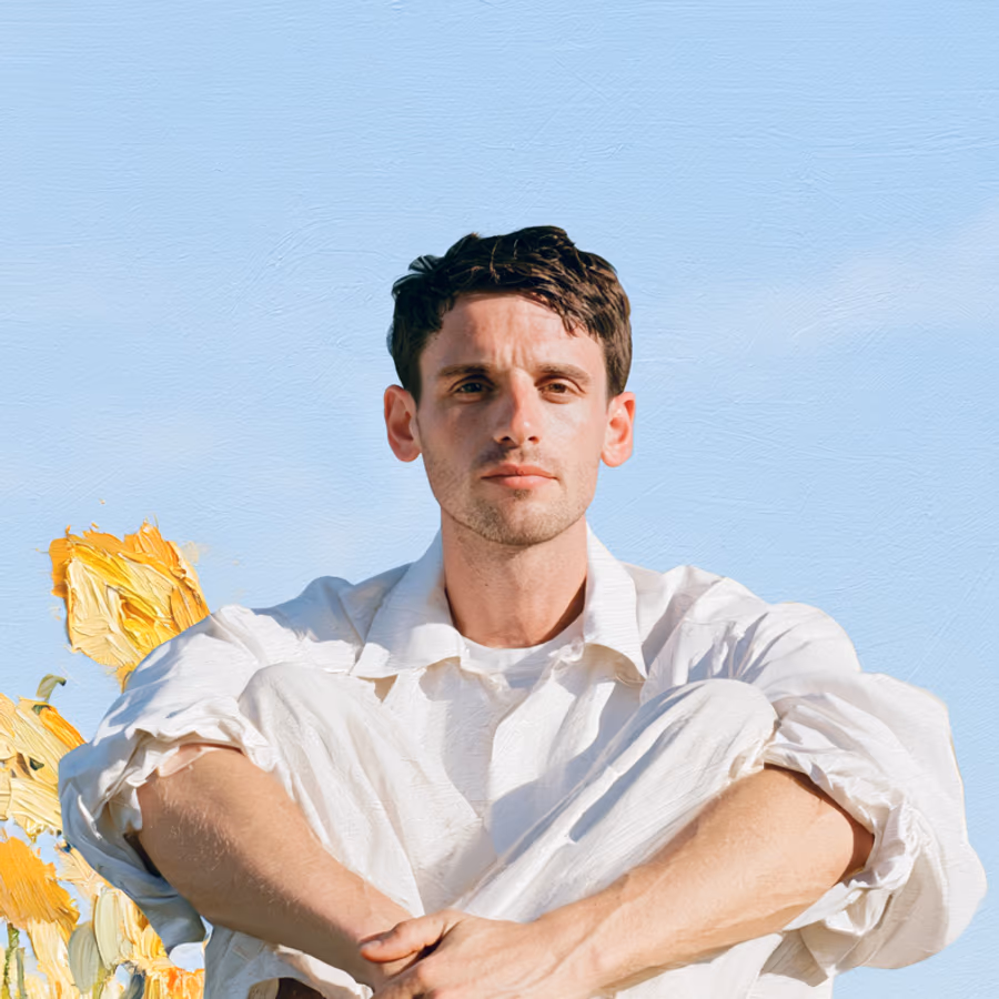 Synthetisches Portrait von wirklich.ai: junger Mann in weißem Hemd vor blauem Himmel, daneben gemalte Sonnenblumen